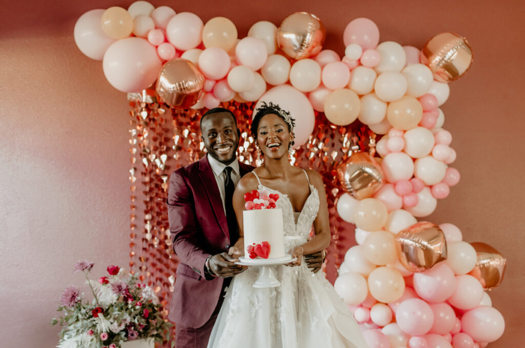 Bride & Groom holding cake in playful and romantic valentine's shoot.