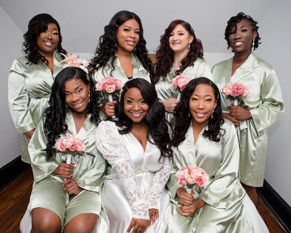 Bride poses with bridesmaids in silk robes before intimate micro wedding ensues.