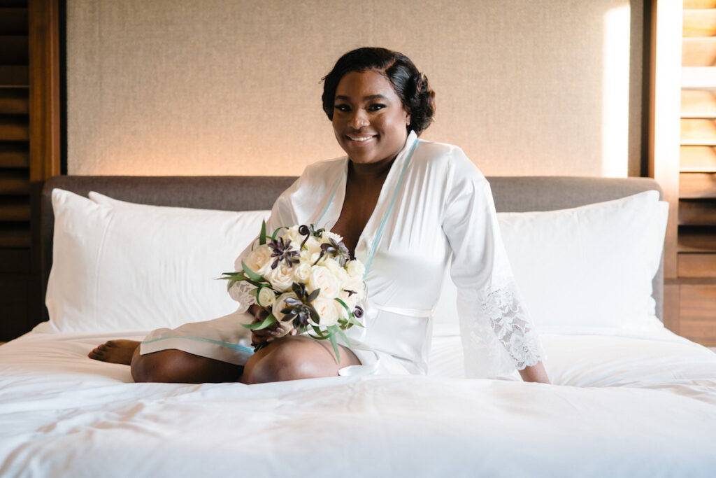 Bride posing pre-wedding in white silk robe before her culture infusion micro wedding begins!