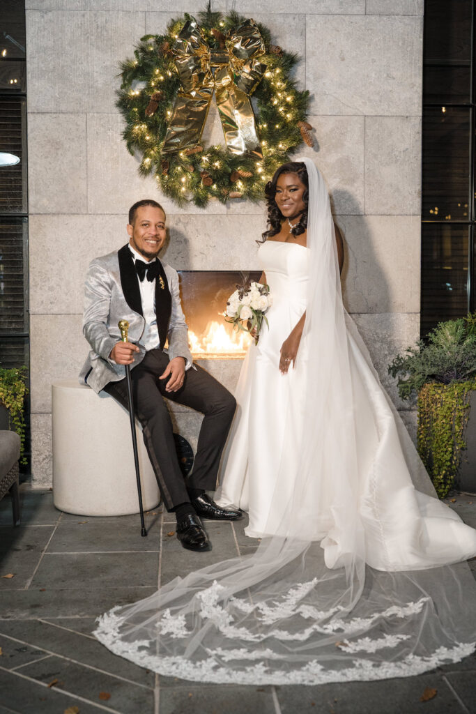 Bride and groom posing in front of fire place in culture fusion micro wedding.
