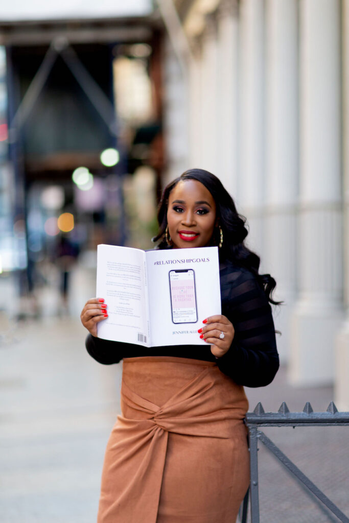 CEO of Just Elope, Jennifer Allen, holding her latest workbook: #RELATIONSHIPGOALS