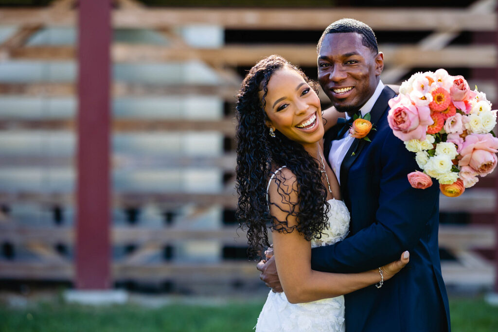 Green pastures, bright florals, a classic red barn, and two glam gowns are highlights of this chic barn wedding in Boston.