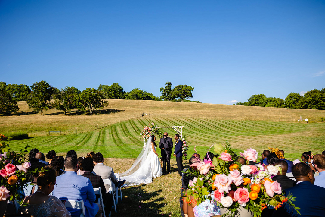 Green pastures, bright florals, a classic red barn, and two glam gowns are highlights of this chic barn wedding in Boston.