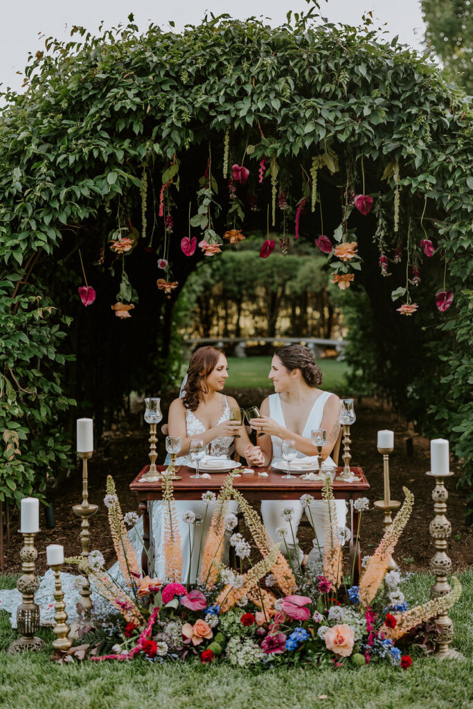 This fairytale garden-inspired styled shoot in Wisconsin highlights the LGBTQ+ community with bold jewel-tone decor and luscious floral art.  