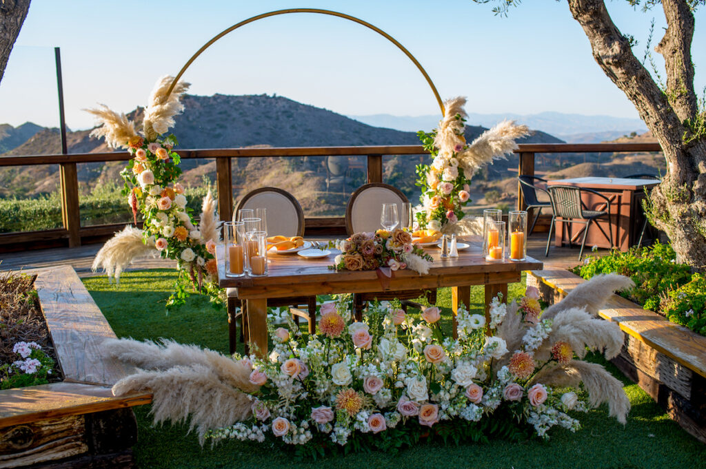 This hilltop vineyard wedding in Malibu is everything sweet with a sunset-inspired color story, an outdoor ceremony, and two glam dresses!