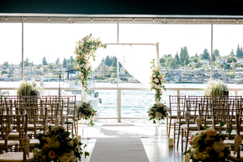 This waterfront wedding at the Tyee Yacht Club in Seattle, WA, features soft pink blooms, pops of red, and a bilingual English/Spanish ceremony.