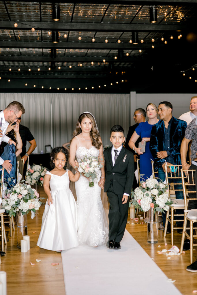 This waterfront wedding at the Tyee Yacht Club in Seattle, WA, features soft pink blooms, pops of red, and a bilingual English/Spanish ceremony.