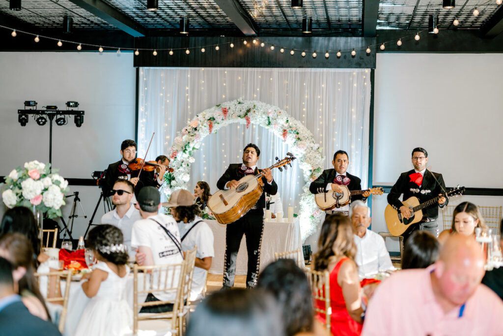 This waterfront wedding at the Tyee Yacht Club in Seattle, WA, features soft pink blooms, pops of red, and a bilingual English/Spanish ceremony.