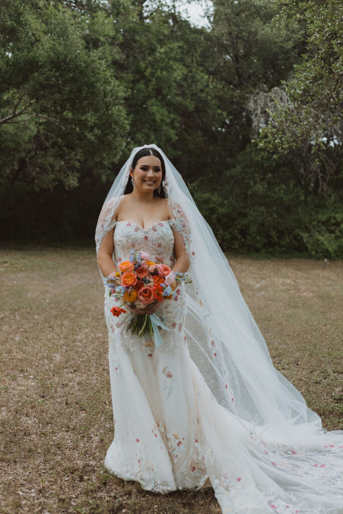 This charming rustic outdoor wedding was filled with vibrant summer florals and an unforgettable Morilee gown.