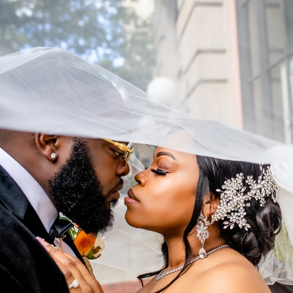 Bride and groom about to kiss under veil